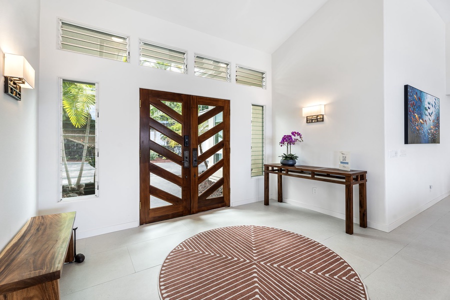 Grand custom entry welcomes you with vaulted ceilings, tropical light, and elegant island style.