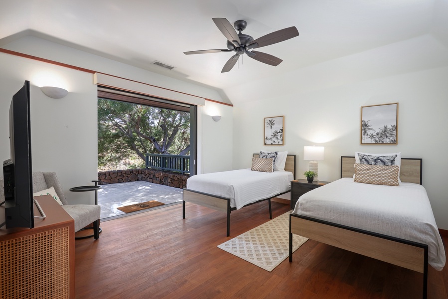 The fourth bedroom offers two twin beds, a smart TV, en suite bath and a spacious private lanai to take in the greenery.
