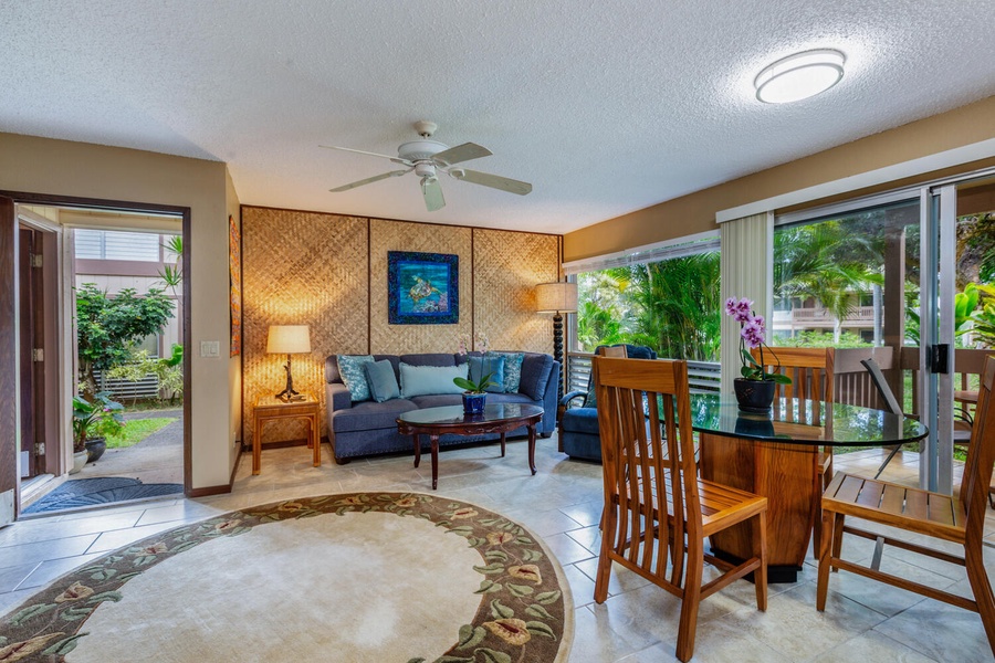 Relax in the inviting living area, featuring a plush couch and glass-walled access to a serene patio.