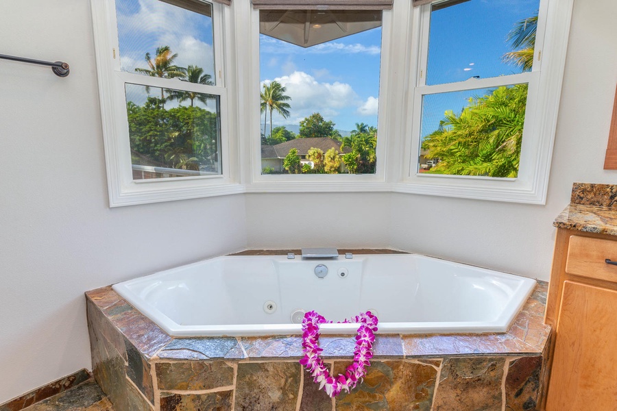 Enjoy a spa-like retreat in Pohaku Villa’s jetted tub with peaceful views of lush tropical greenery.