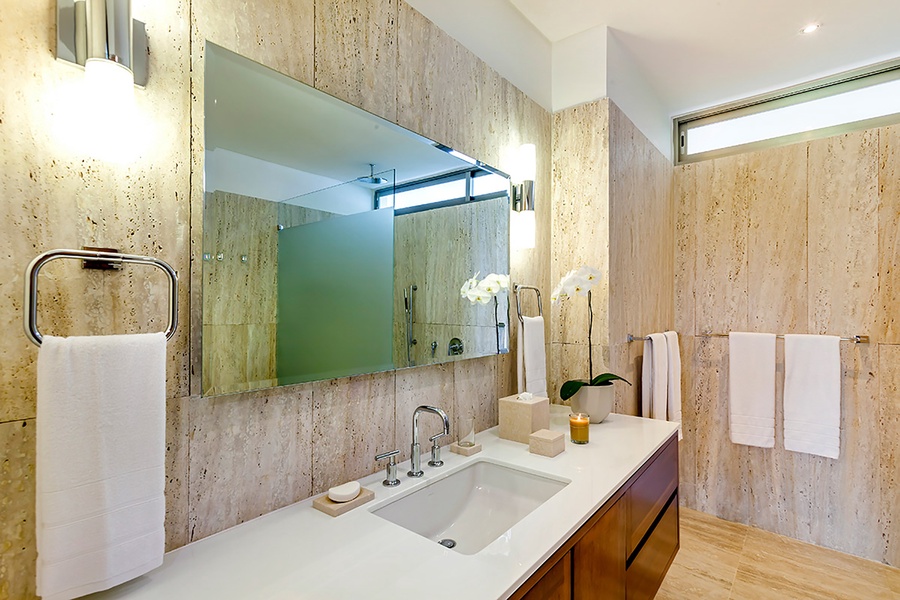 The guest bathroom has a single vanity and separate shower.