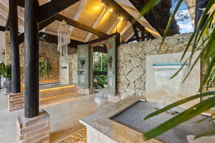 Experience the rustic elegance of Casa Tamarindos, with charming stone walls, vintage doors, and soothing water features.