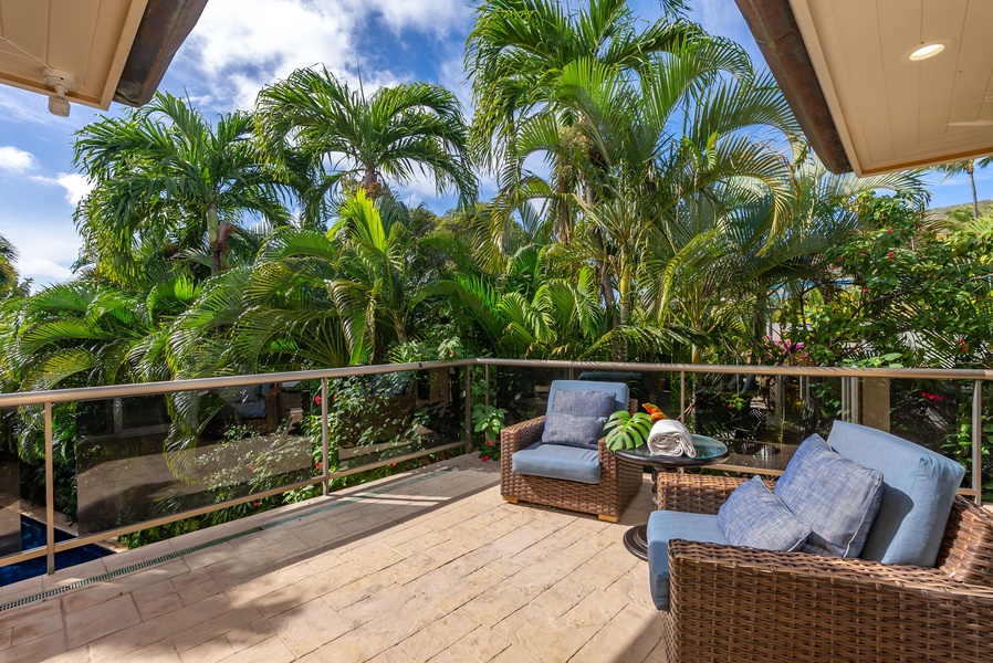 Relax on your private lanai with comfortable wicker seating, surrounded by swaying palm trees and tropical paradise views.