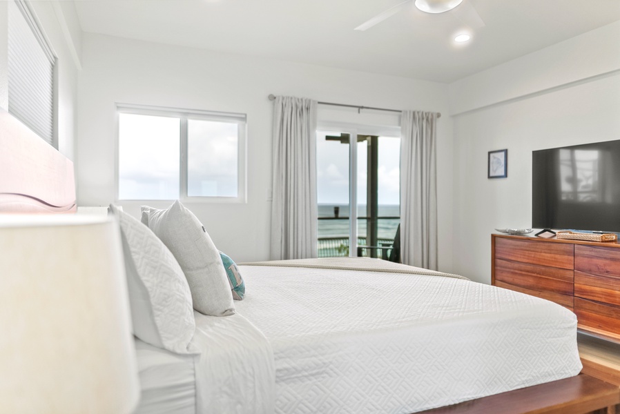 Serene oceanfront bedroom with crisp linens and soft natural light—perfect for slow mornings and restful nights.