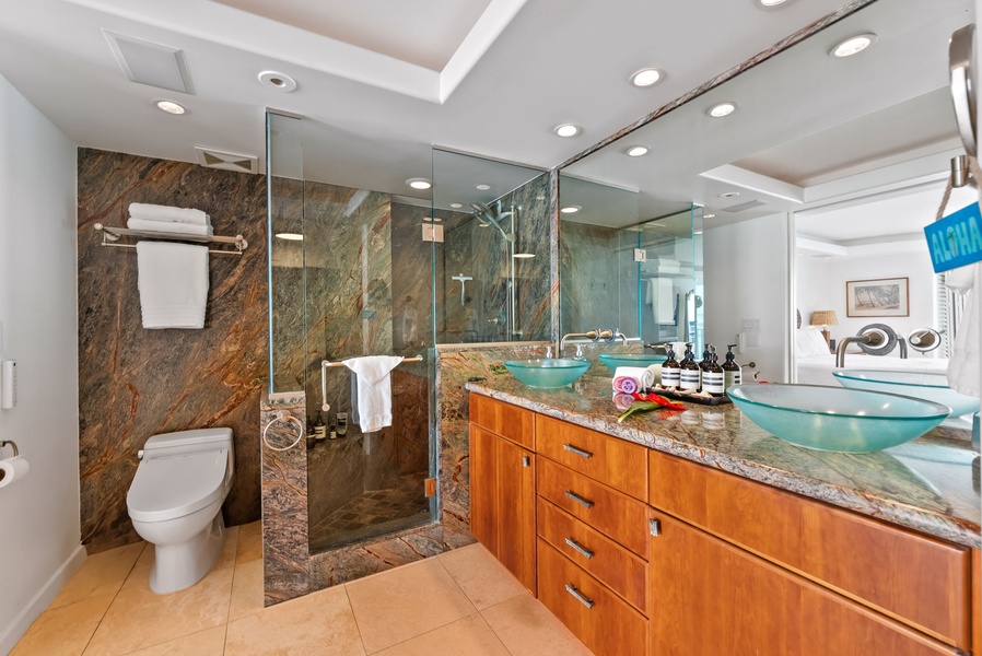 Luxurious bathroom with double vanity, glass-enclosed shower, and marble finishes, creating a spa-like experience for ultimate relaxation