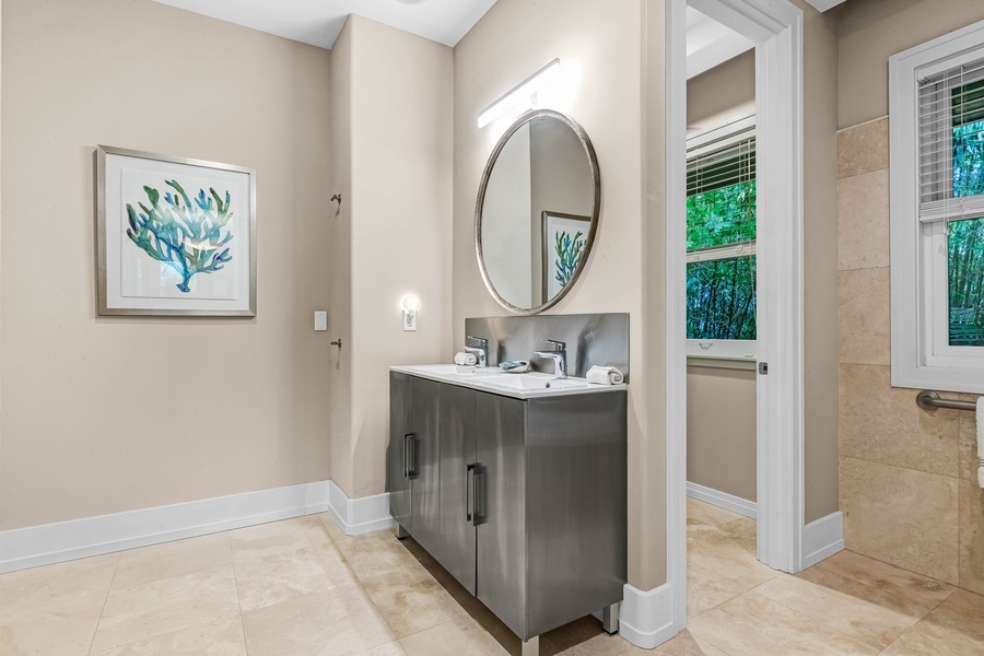 Bathroom with modern vanity, circular mirror, and clean finishes.