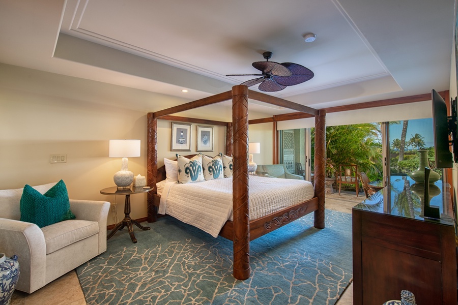 The primary suite is a serene retreat, featuring a luxurious king-size bed, large windows with ocean views, and direct access to the lanai.