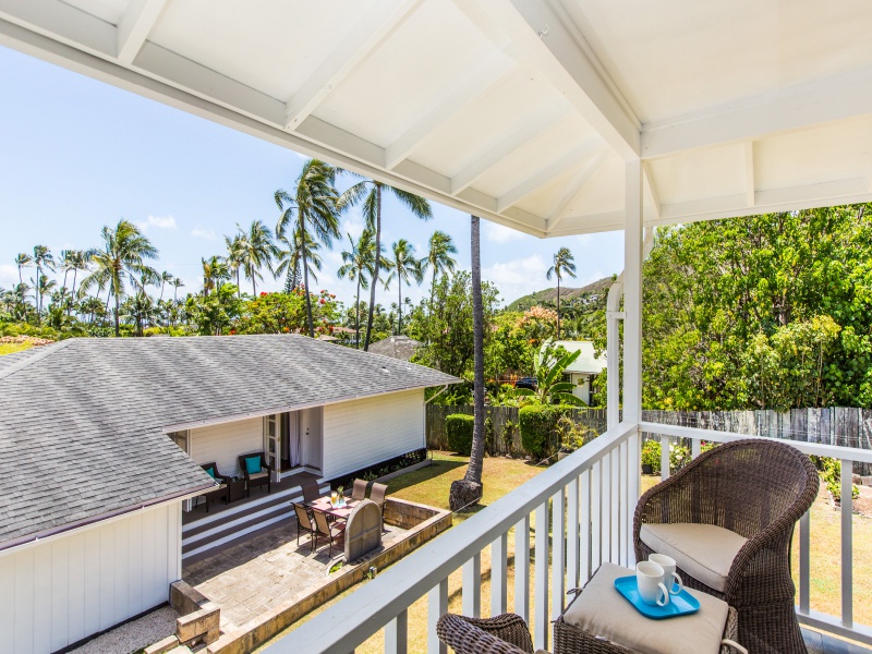 The guest cottage lanai overlooks the large yard and main house, with glimpses of the tropical surroundings.