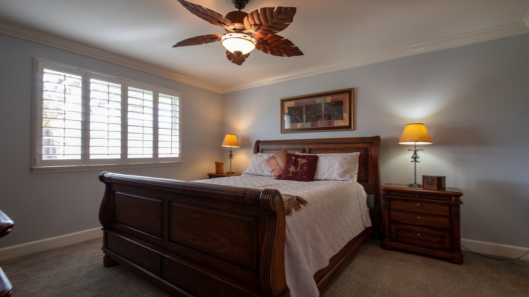 The spacious primary guest bedroom with soft linens and a ceiling fan.