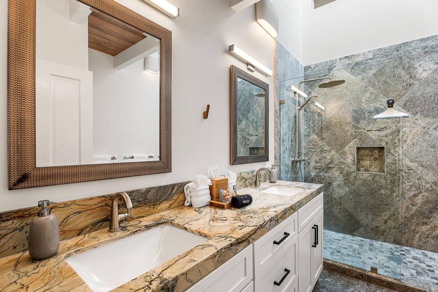Refresh in a private bath with dual vanities and a spacious walk-in shower.