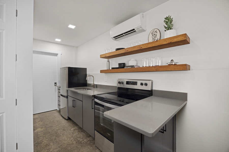 Convenient kitchenette with full-size appliances, open shelving, and plenty of prep space — great for guests or teens.