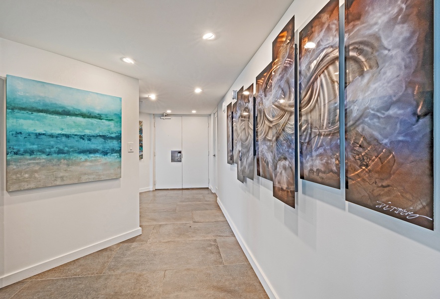 A hallway adorned with modern art provides an elegant and welcoming entrance to this beautiful space.