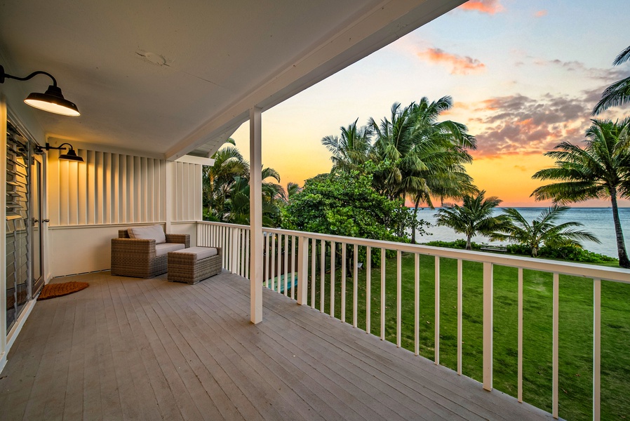 Relax on the porch with seating and swaying palms in view.