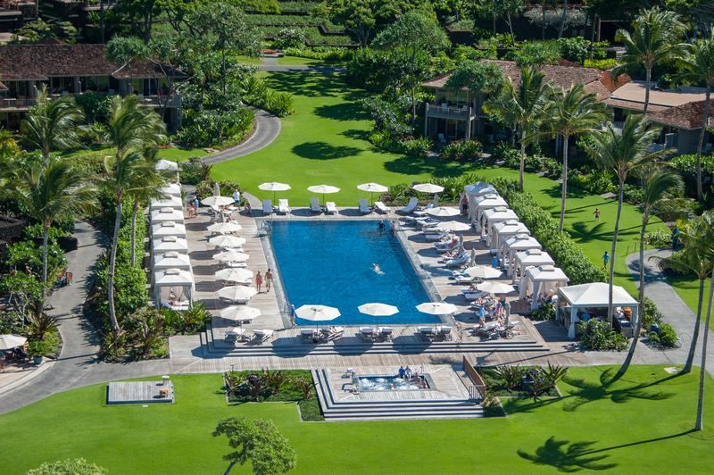 Let your vacation begin at the luxurious community pool at the Hualalai Resort, a serene oasis for relaxation.