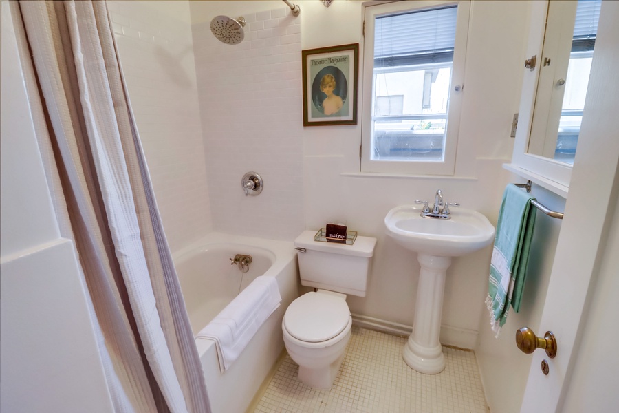 The shared bathroom has single vanity and shower-tub combo.