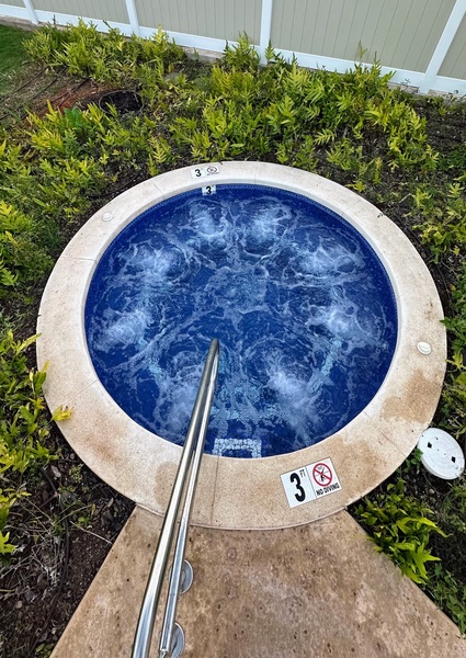 Enjoy a peaceful soak in the private hot tub with tropical mountain ambiance.