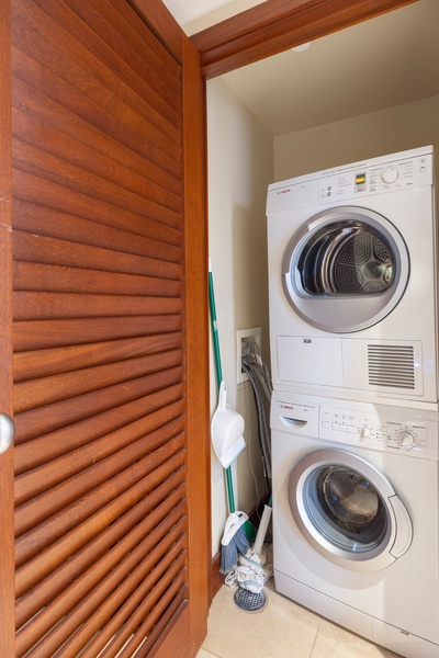 Your private laundry nook keeps clothes fresh with stackable washer and dryer tucked behind beautiful wooden doors.