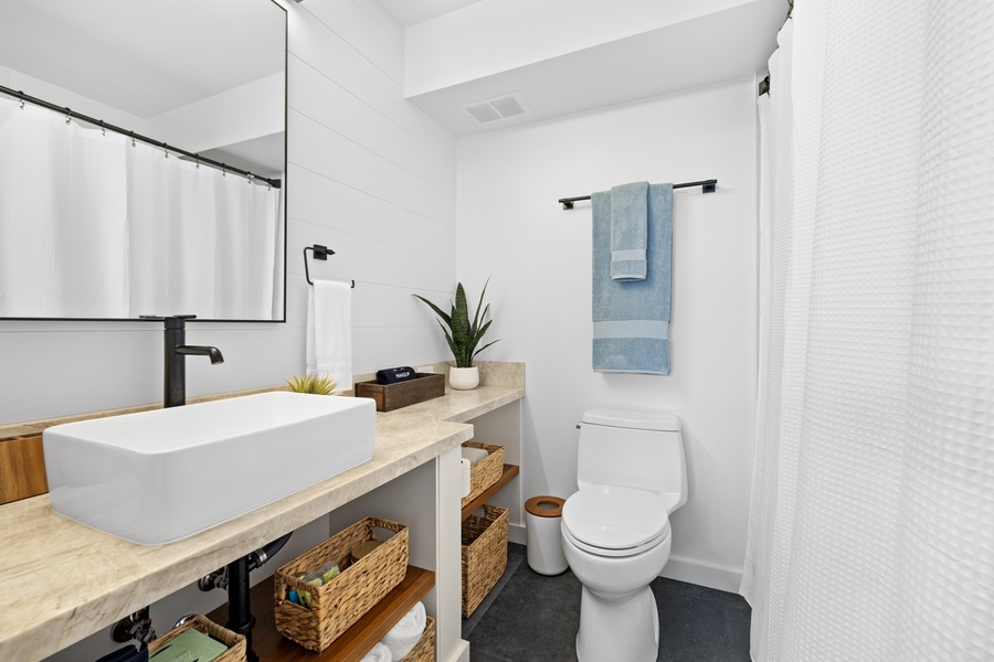 Refresh in this elegantly simple bathroom, complete with modern fixtures and warm, natural accents.