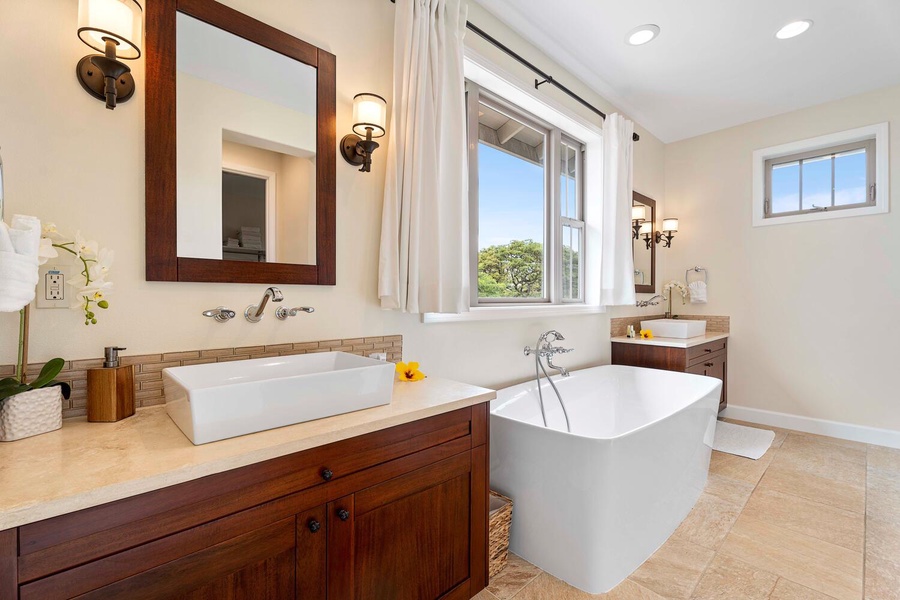 Elegant primary ensuite bathroom with a freestanding tub and rustic wooden accents.