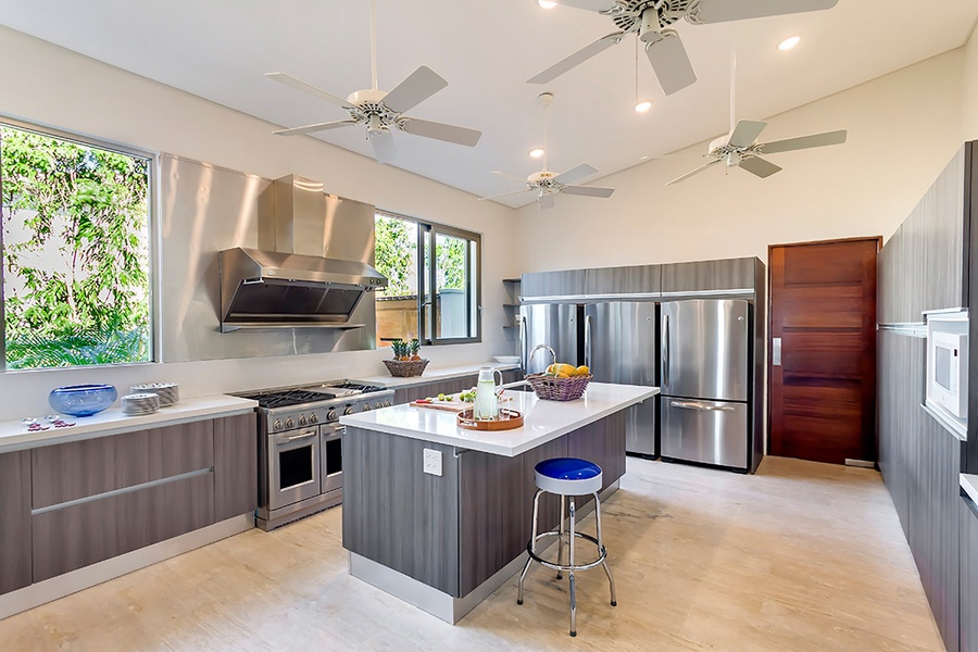 The fully-stocked kitchen features stainless steel appliances and wide counter spaces.