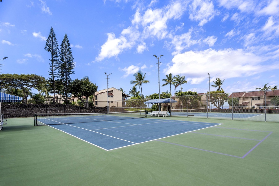 Play a round of tennis while surrounded by swaying palms and blue skies