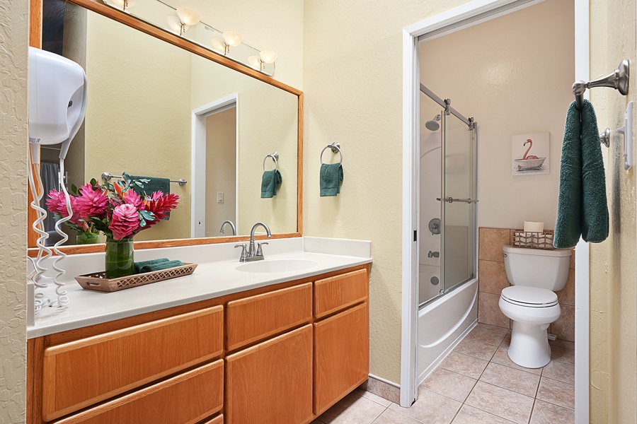 The spacious ensuite bathroom has a shower/tub combo and vanity area.
