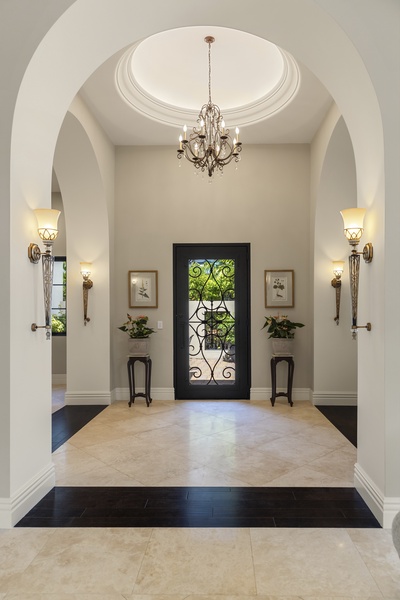 Grand entryway featuring high ceilings, elegant chandeliers, and a welcoming atmosphere.