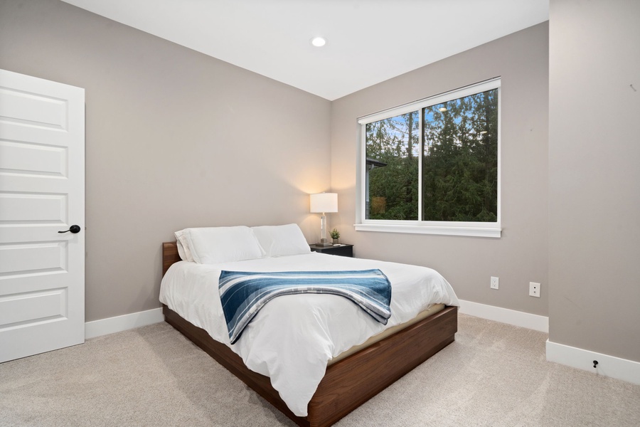 Your peaceful bedroom sanctuary awaits with crisp linens, warm lighting, and a serene garden view to start each morning refreshed.