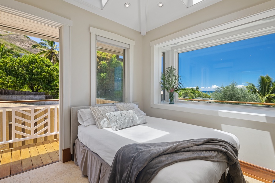 Relax on the guest bedroom with large windows, lanai and ocean views.
