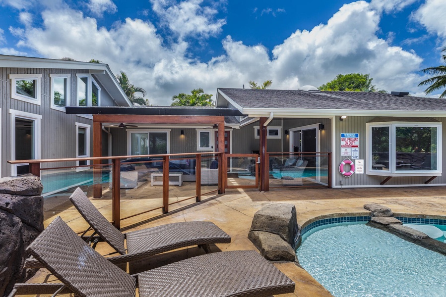 Expansive poolside patio at Lani Oasis with loungers and easy indoor-outdoor access.