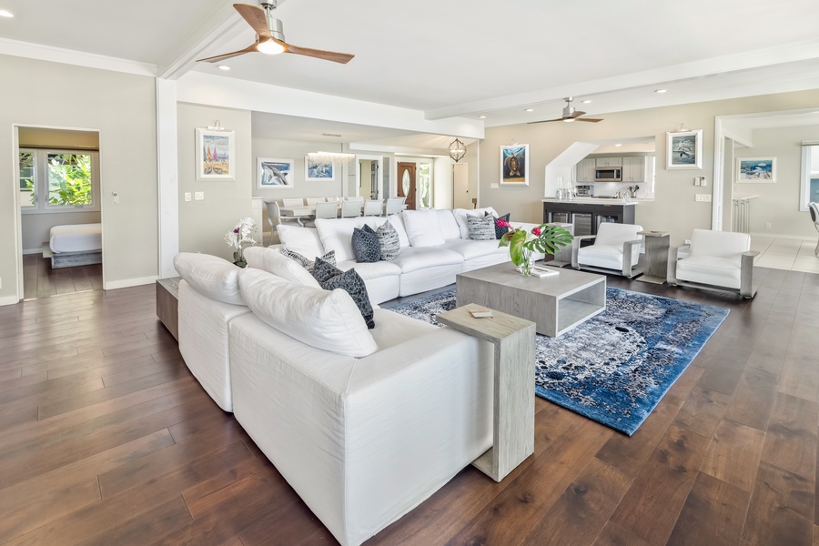 The living area features plush sectional sofas, TV and split AC.