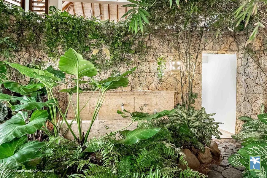 Immerse yourself in a tropical oasis with lush greenery and natural stone surroundings.