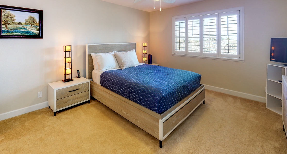 The spacious primary guest bedroom with gorgeous lighting.