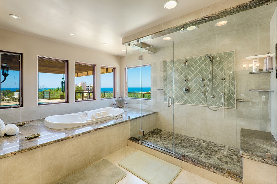 Primary bathroom with jetted tub and spacious shower with ocean views