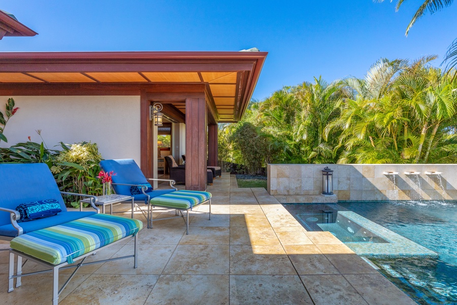 Sunlit lounging deck by the sparkling pool and garden backdrop.