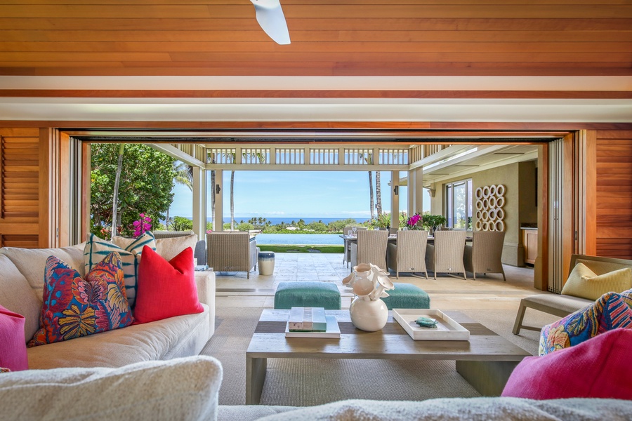 Great room seating expanding to the covered lanai, pool, and ocean beyond.