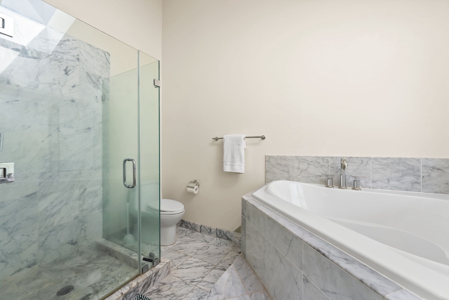 Elegant bathroom with a glass-enclosed walk-in shower and separate soaking tub, designed for relaxation.