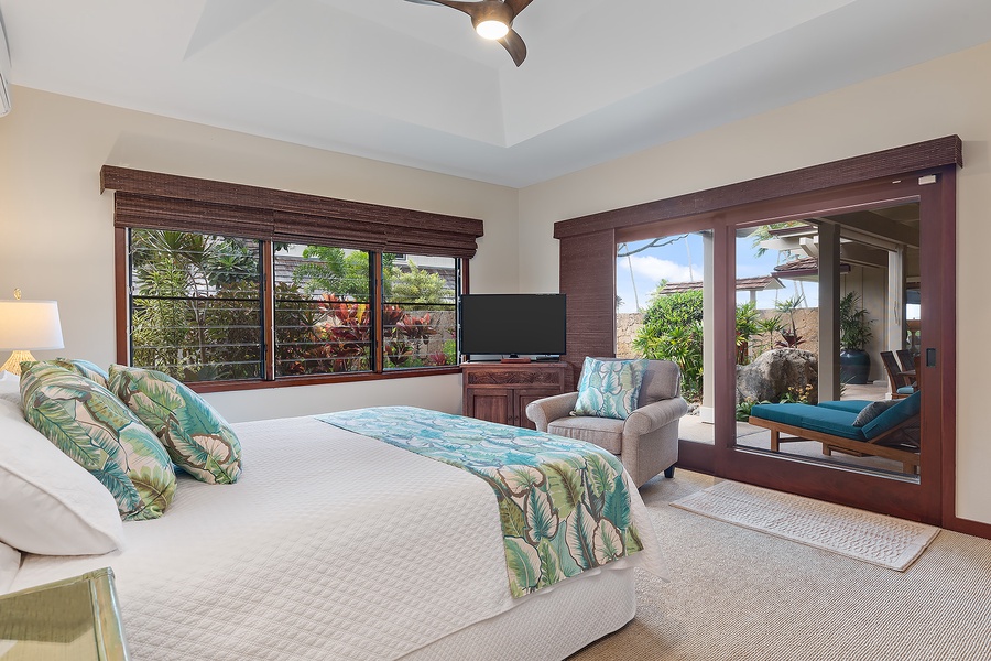 Beach house spacious guest bedroom with a king-size bed, cozy seating, and garden vistas.
