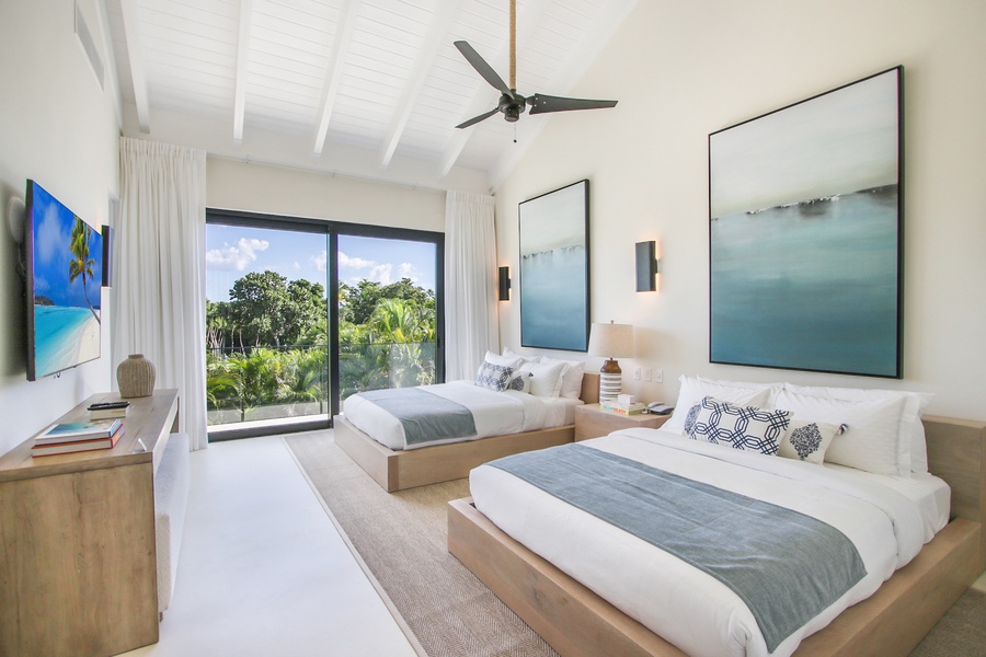 The guest bedroom with two cozy beds and garden views.