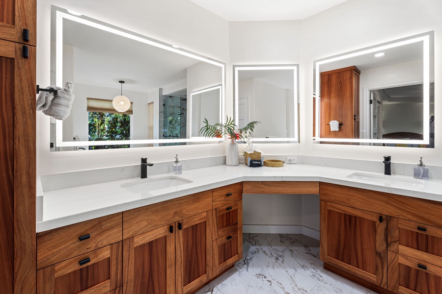 Start your mornings in this stunning bathroom with dual sinks, warm wood vanities, and LED-lit mirrors that make getting ready effortless.
