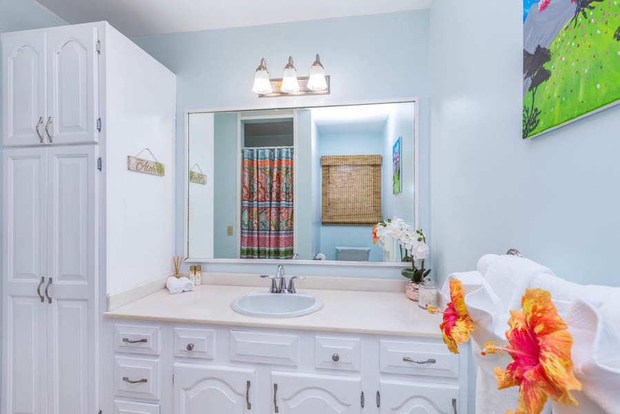 A spacious and inviting bathroom with a single vanity and vibrant decor accents.