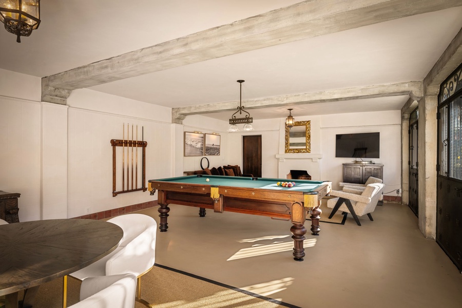 Challenge friends to billiards in this elegant game room, featuring rustic beams, comfortable seating, and entertainment center for perfect evenings in.
