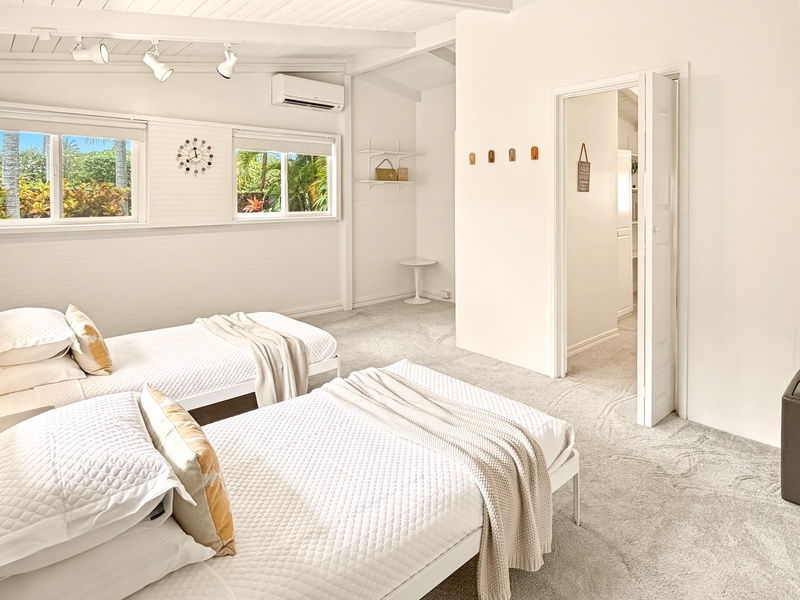 Wake up in your serene twin bedroom with tropical garden views, crisp white linens, and modern comfort.