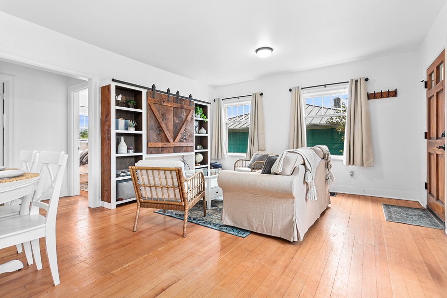 The main living room features warm hardwood floors, soft seating, and a large TV—perfect for unwinding after a day of exploring.