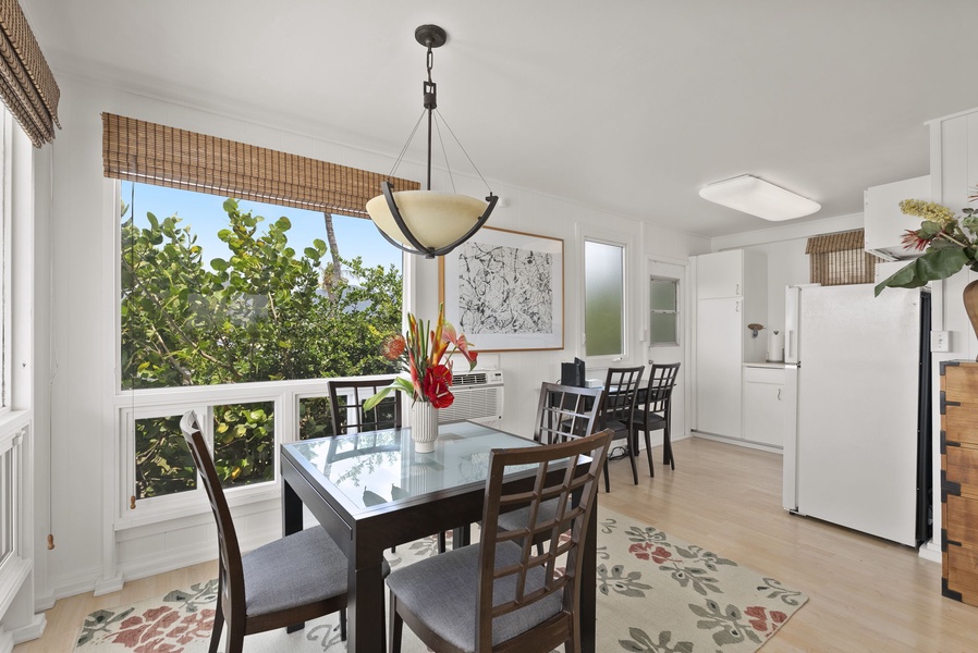Gather around your elegant dining table for memorable meals, with natural light streaming through bamboo shades and garden views beyond.