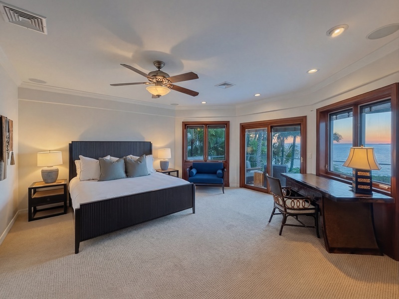 Drift to sleep in your spacious bedroom with ocean views through floor-to-ceiling windows and a gentle ceiling fan creating the perfect tropical breeze.