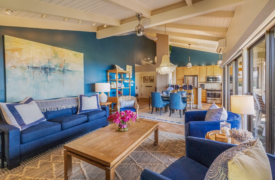 A cozy living room with a large sofa, a bright blue accent wall, and plenty of natural light