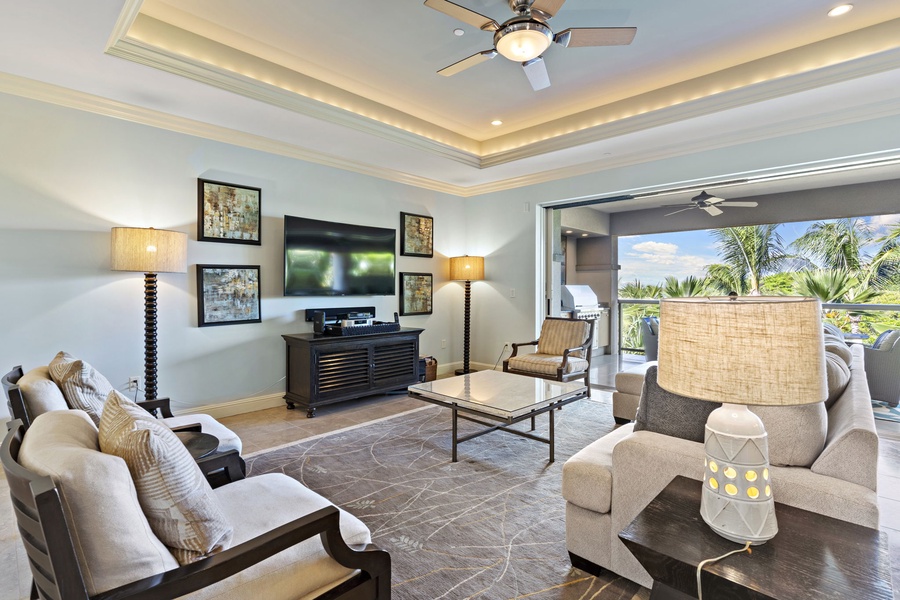 Relax in the comfortable living area of Wailea Hoolei 93-3, featuring plush seating, a large TV, and lanai access.