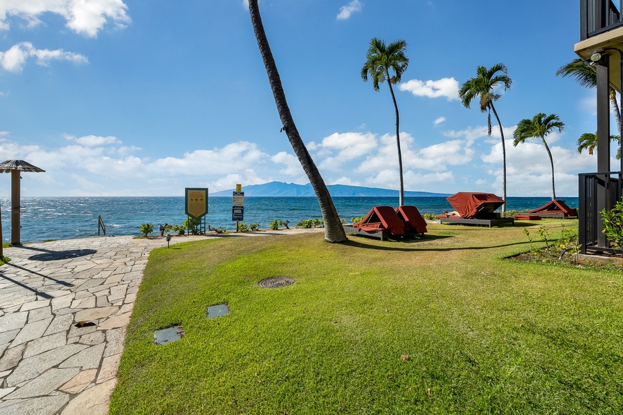 Lounge chairs with grass, ocean, and mountain views at Kaanapali Shores.