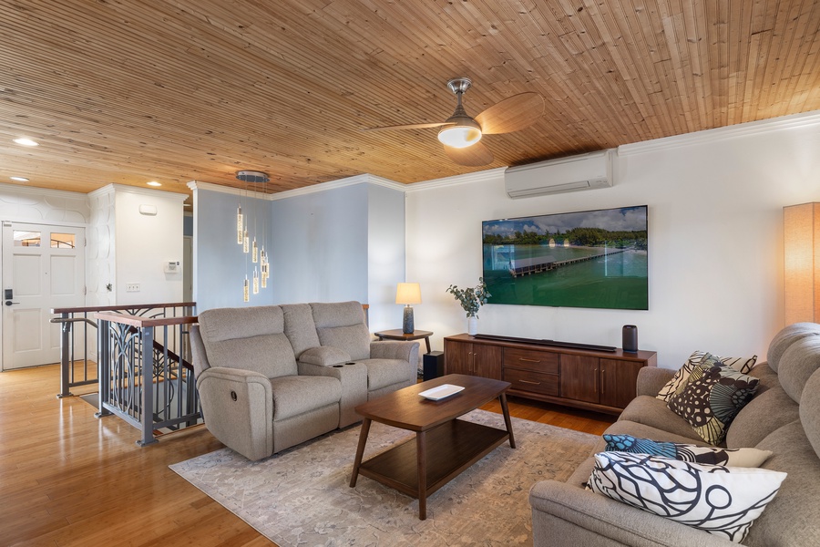 The upstairs living space is furnished for comfort and flow, with large windows, AC, and access to indoor and outdoor relaxation zones.
